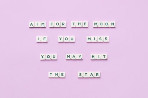 Inspirational message using Scrabble tiles on a pastel background.
